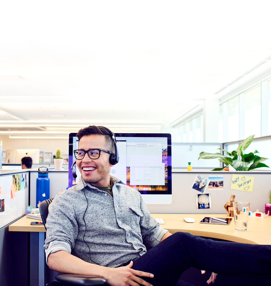 Een Apple Support Advisor aan zijn bureau op de Apple campus ontspant even tussen twee telefoontjes door.