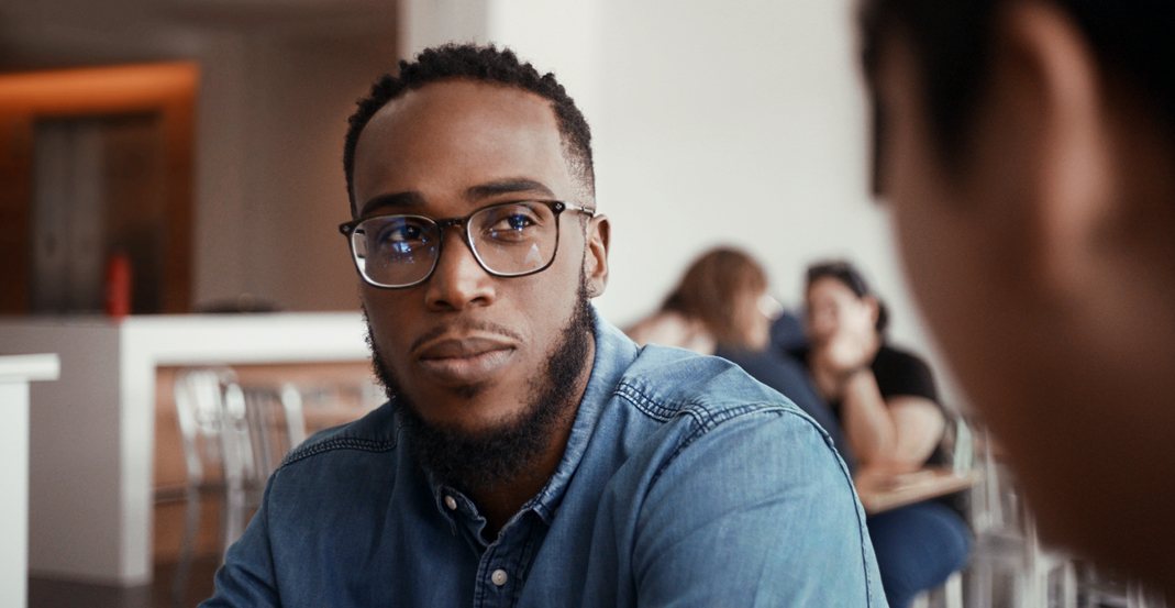 Shaunte, een Apple Support Advisor, tijdens een gesprek met zijn Manager in een kantoor bij Apple.