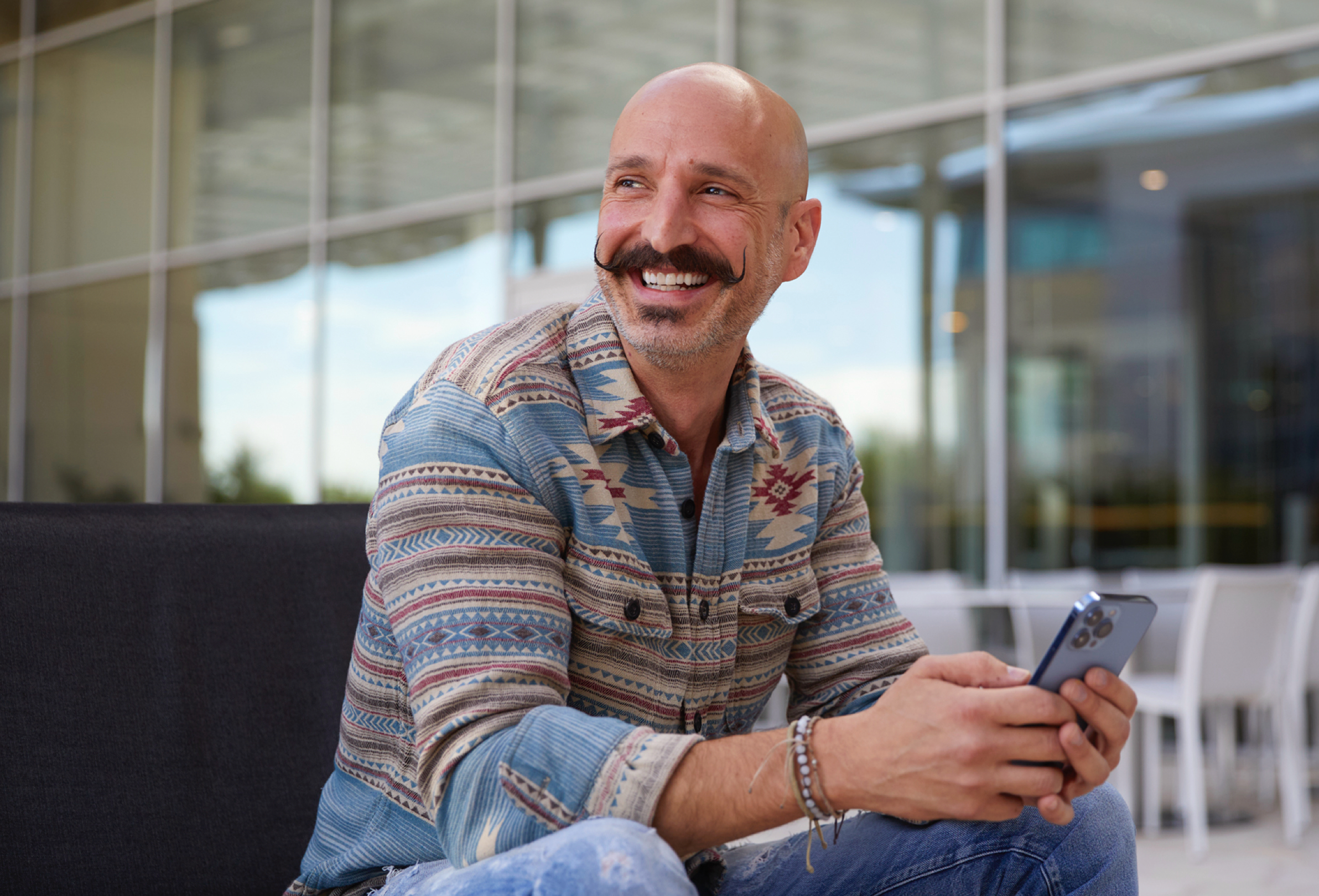 An Apple employee looking to the side and smiling.