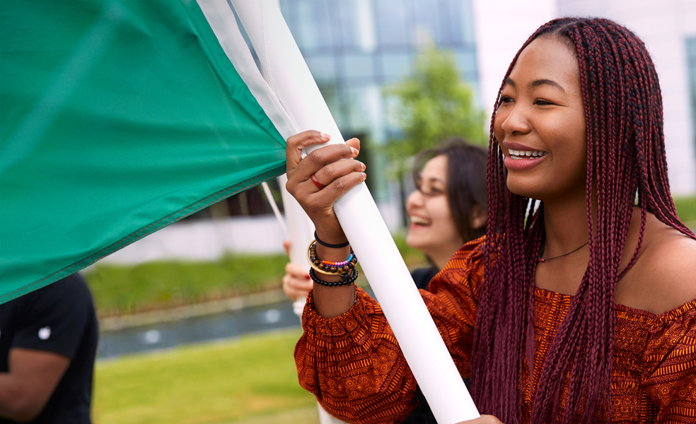 Une employée d’Apple Cork défile en brandissant un drapeau.