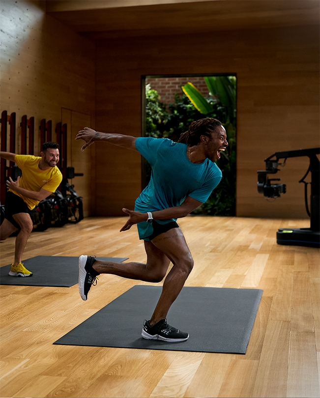 Des coachs Apple Fitness+ enregistrant une séance dans un studio vidéo. 