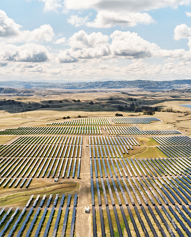 Vue aérienne d’une vaste plaine sur laquelle sont installés des panneaux solaires.