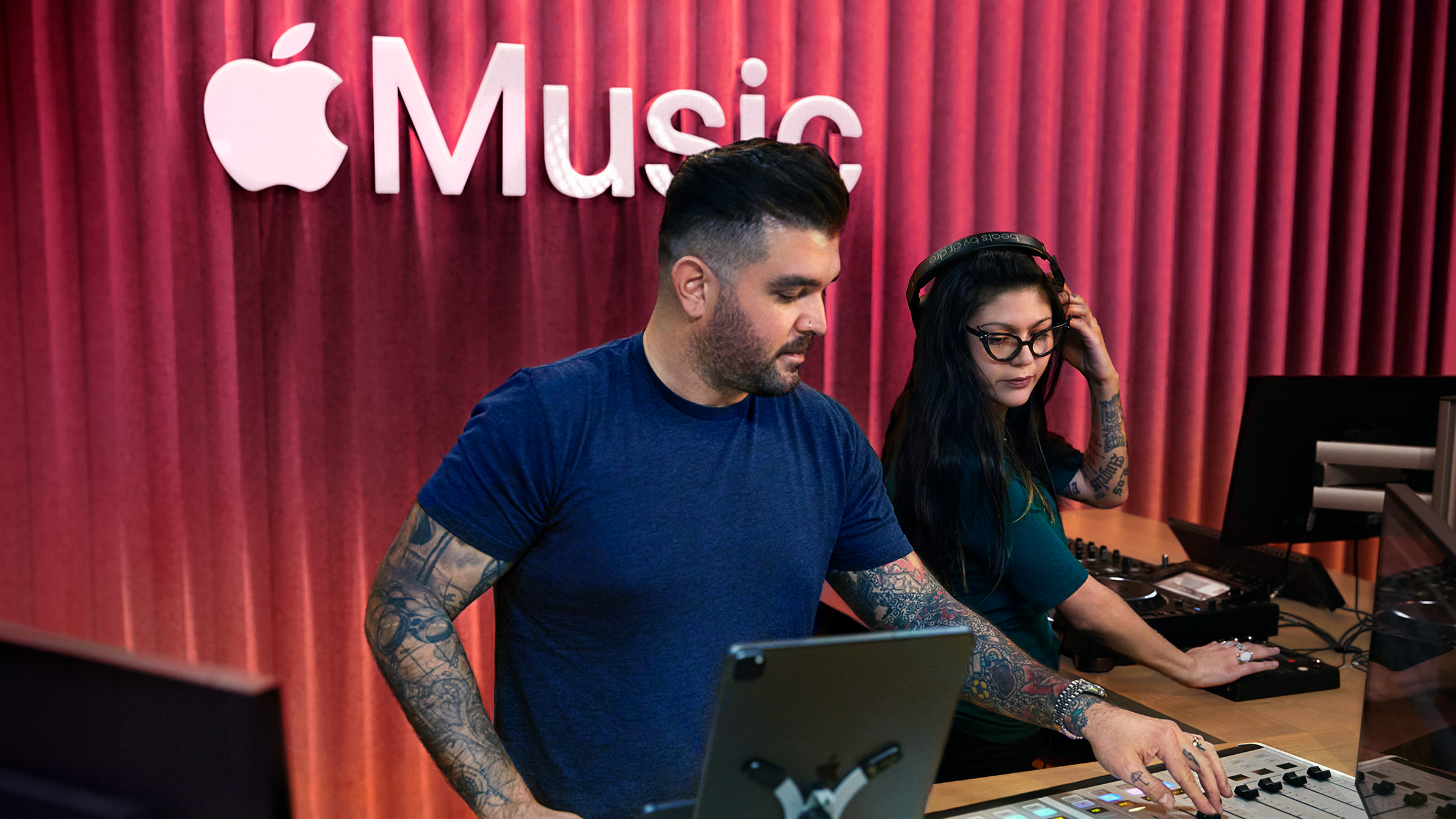 Deux collègues Apple utilisent une table de mixage dans un studio Apple Music.