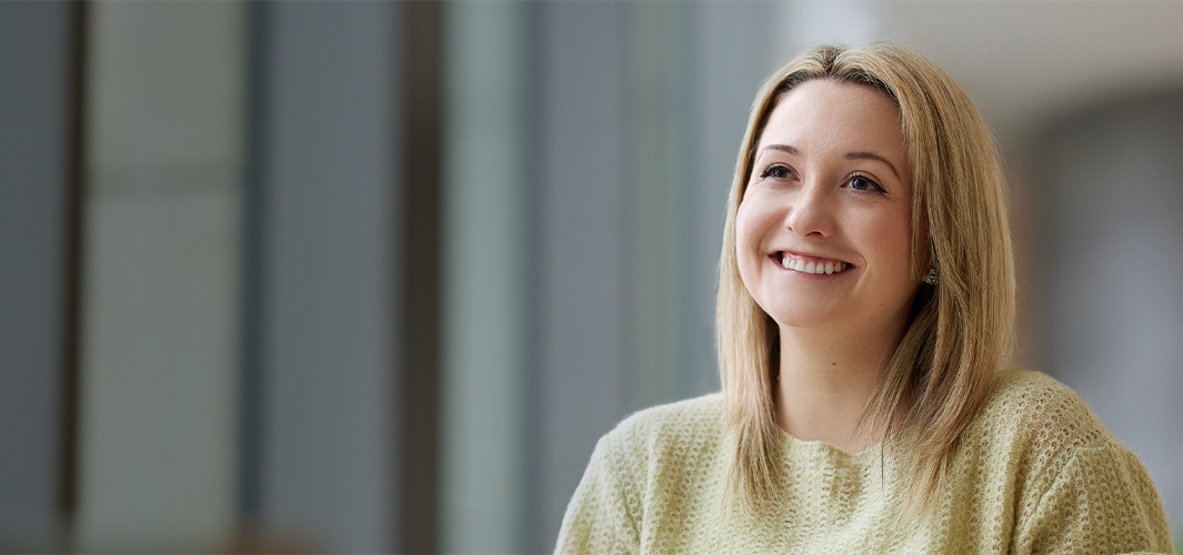 Georgia sourit, assise, le regard tourné vers la gauche.