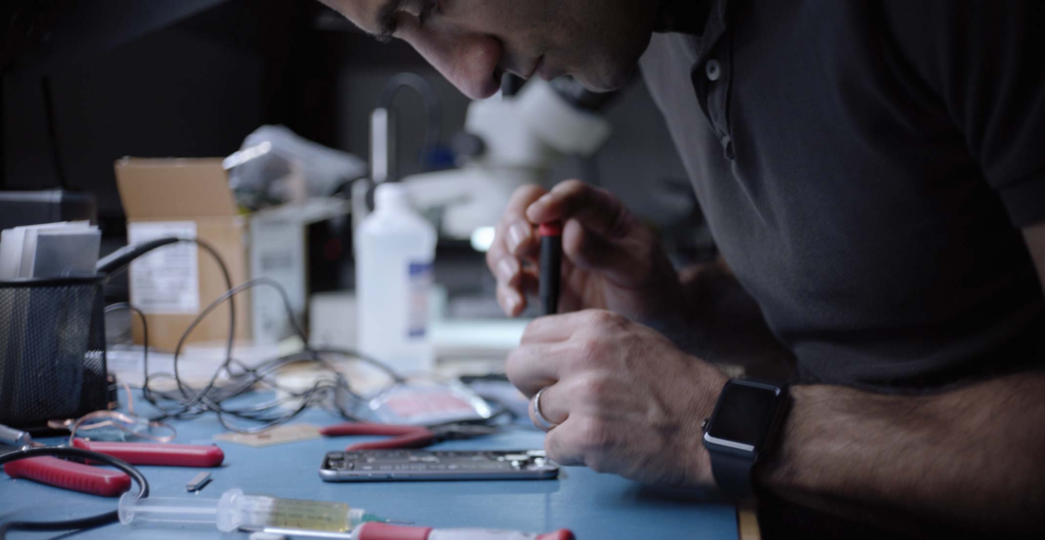 Ehsan, en teknisk leder i teamet for utvikling av berøringsteknologi, jobber med en iPhone i en teknisk lab.