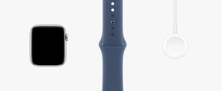 Une Apple Watch SE vue de face, un bracelet sport comète et un câble de recharge magnétique USB-C placés côte-à-côte.