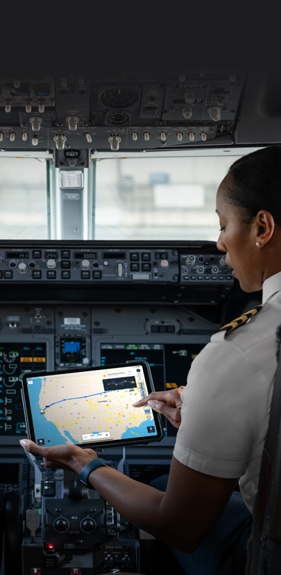 Une pilote d’avion, dans son cockpit, consulte une carte sur l’écran d’un iPad.