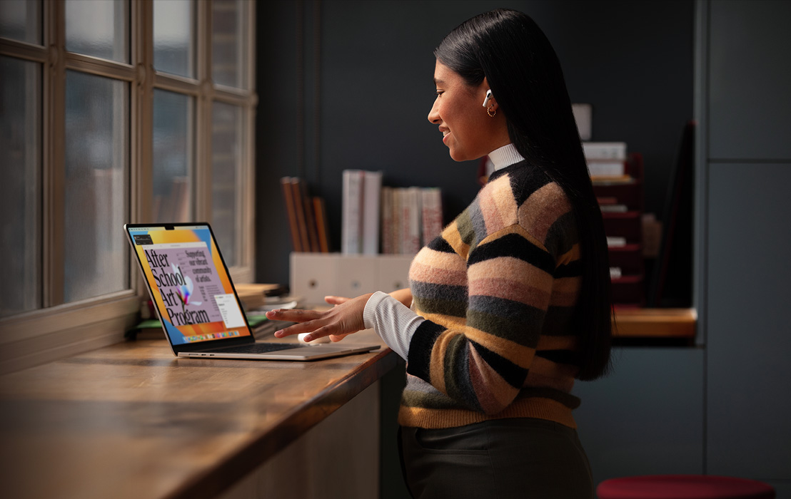 Una estudiante universitaria crea un folleto en un MacBook Pro